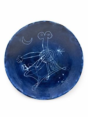 une assiette bleue sur laquelle est dessiné un personnage
