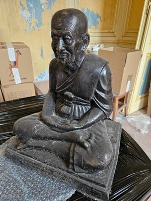 une statue d'un homme assis sur une table