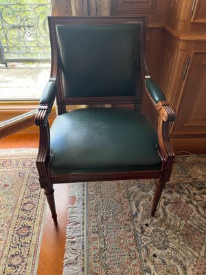 un fauteuil en cuir vert placé devant une fenêtre