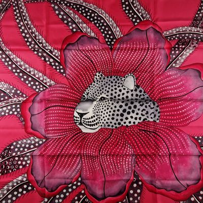 a large red and black flower with a leopard on it