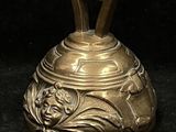 a gold bell with a face on it on a black background