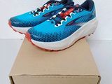 a pair of blue and red running shoes on top of a cardboard box