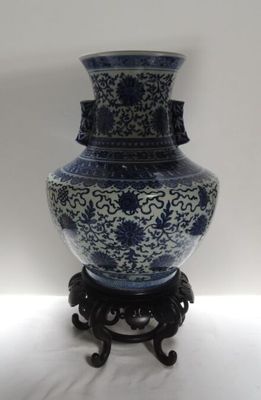 un vase bleu et blanc posé sur un socle