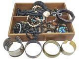 a wooden box filled with assorted jewelry and bracelets