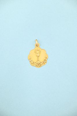 a gold pendant with a picture of a woman on it