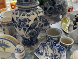 a table with blue and white dishes and vases on it