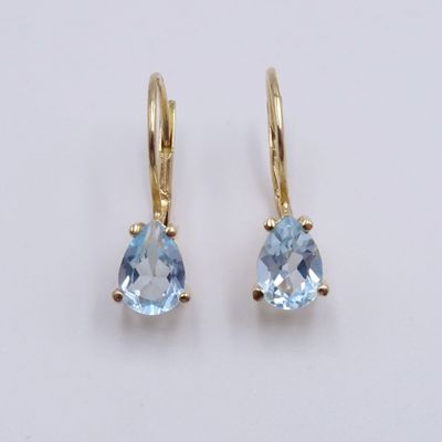 une paire de boucles d'oreilles en topaze bleue sur fond blanc