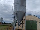 un grand silo métallique situé au milieu d'un champ