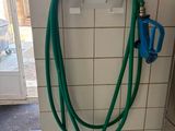 un tuyau vert fixé au mur d'une salle de bains
