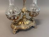 two glass vases sitting on a stand on a table