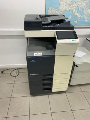 une imprimante multifonction posée par terre devant une carte