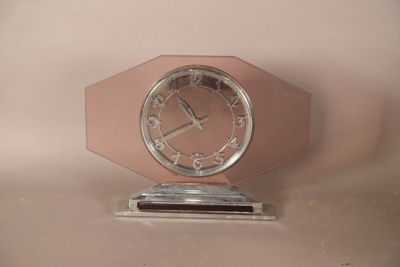 une horloge rose posée sur un socle en métal