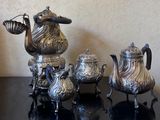 three silver teapots sitting on a table next to each other