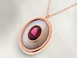 une photo d'un collier orné d'une pierre rouge