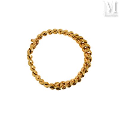gros plan d'un bracelet en or sur fond blanc