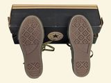 pair of black shoes with brown soles on top of a black suitcase