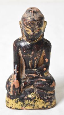 statue représentant une personne assise en position de méditation sur une surface blanche