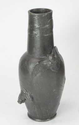 un vase noir posé sur une surface blanche