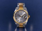 an image of a silver and gold watch on a blue surface