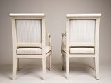 two white chairs with striped upholstered seats on them