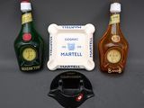 three bottles of liquor and a ashtray on a table