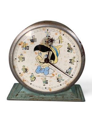 une horloge ornée d'un personnage de dessin animé, posée sur un socle