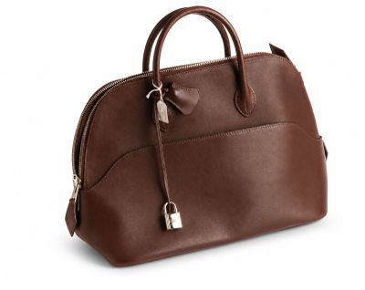 Le sac à main en cuir marron est posé sur une surface blanche.