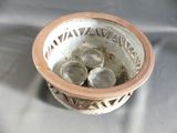 a brown and white bowl with four cups in it