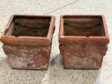 deux pots marron posés par terre l'un à côté de l'autre