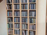 une grande bibliothèque en bois remplie de CD et encore de CD