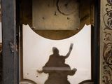 a clock that has a shadow of a person on it