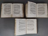 three old books are stacked on top of each other on a table