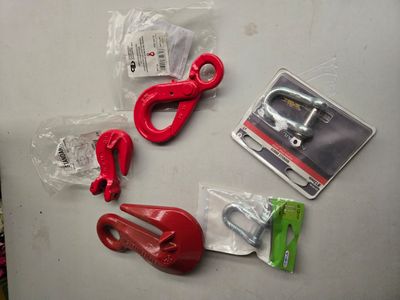 quelques crochets rouges et une paire de ciseaux posés sur une table