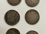 six different british coins on a white surface