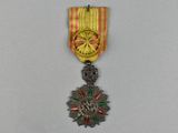 une médaille d'or entourée d'un ruban rouge et jaune