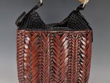 a brown woven bag with a wooden handle and handles