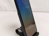 a close up of a cell phone on a stand on a white surface