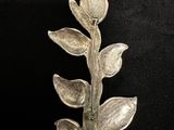 silver plated flower brooch with leaves on a black background