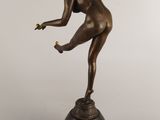 an image of a bronze statue of a woman holding a tennis racquet
