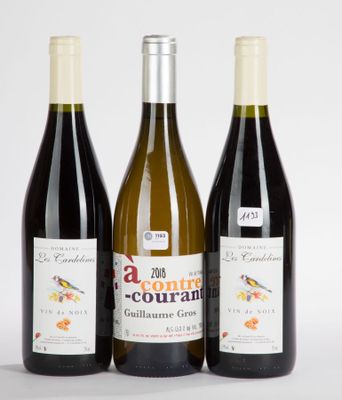 trois bouteilles de vin posées les unes à côté des autres sur une surface blanche