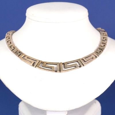 un gros plan d'un collier porté par un mannequin sur fond bleu