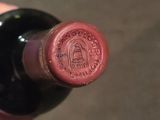 a person holding a wine bottle that has a stamp on it