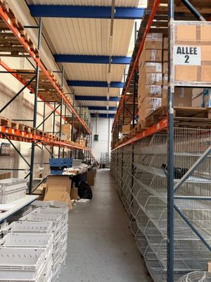 des rayonnages dans un entrepôt, sur lesquels sont empilées des caisses et encore des caisses de denrées alimentaires