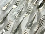 a lot of spoons that are wrapped in plastic