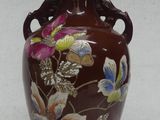 a brown vase with flowers on it on a table