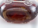 a close up of a bottle of liquor on a white surface