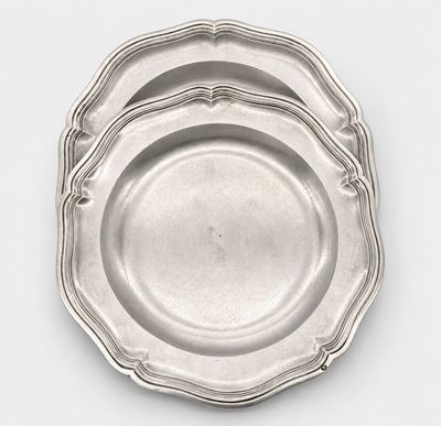 three silver plate on a white surface with a white background