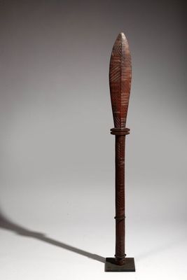 an image of a wooden object on a stand with a shadow on the ground