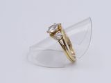 an image of a gold and diamond ring on a clear ring holder