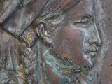 a close up of a bronze plaque with a woman wearing a headdress
